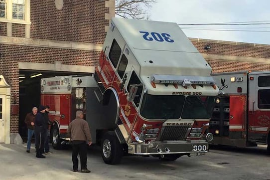 Firefighters performing truck checks on fire engine outside the fire department.